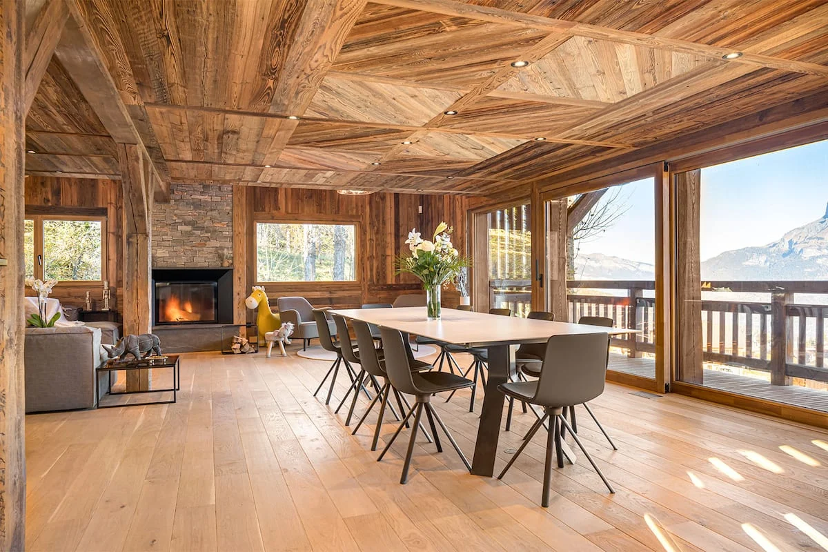 A warm, timber-lined dining and living space with mountain views.